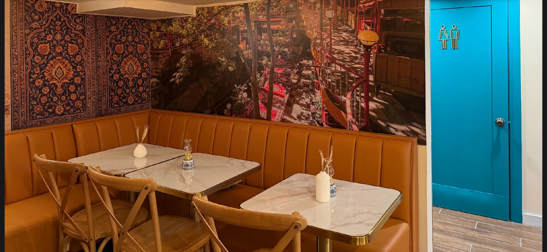 Cognac banquette booth beneath a Shiraz teahouse mural at Taftoon NYC